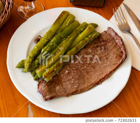 Prepared steak of beef with asparagus at plate Prepared steak of beef with asparagus at plate 72802631
