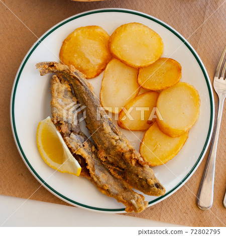 Fried blue whiting fish with potato 72802795