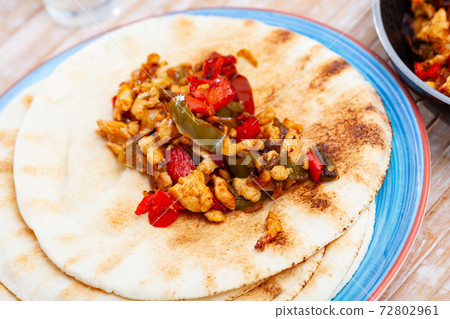 Roasted chopped chicken with vegetables on pita 72802961