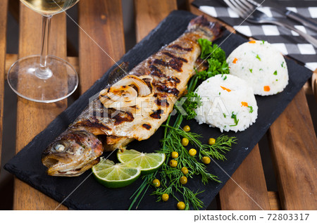 Baked whole trout with rice and wine Baked whole trout with rice and wine 72803317