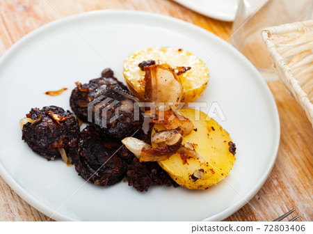 Blood sausages served with potato and onion Blood sausages served with potato and onion 72803406