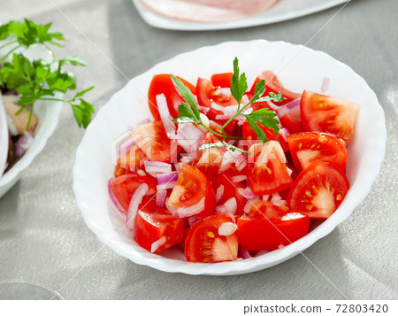 Fresh salad with tomatoes and chopped onion 72803420