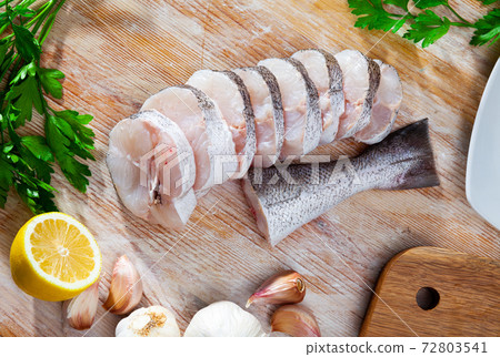 Raw hake sliced on cutting board 72803541