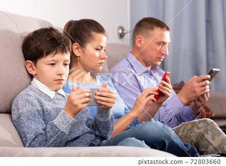 Boy and his parents using phones Boy and his parents using phones 72803660