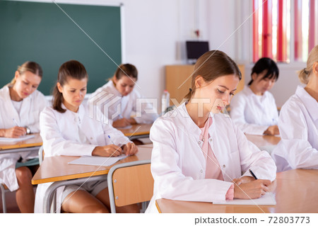 Medical students writing in notepads Medical students writing in notepads 72803773