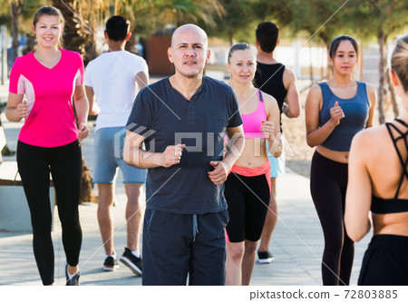 People jogging on city seafront 72803885
