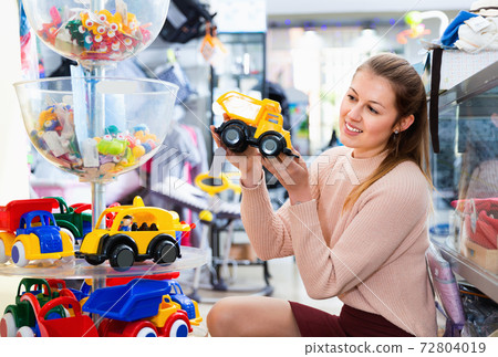 Woman buyer choosing toys for baby in the shop of toys for children 72804019