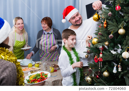 Smiling boy decorating Christmas tree with father Smiling boy decorating Christmas tree with father 72804060