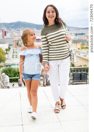 Young woman tourist and daughter walking at the street Young woman tourist and daughter walking at the street 72804470