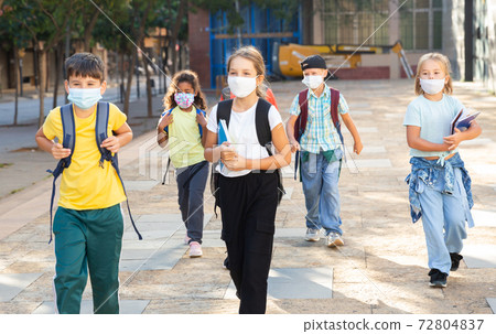 Tween boys and girls in protective masks going to school lessons Tween boys and girls in protective masks going to school lessons 72804837