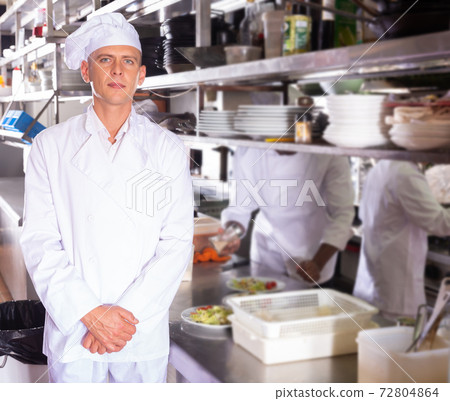 portrait of smiling male chef standing in modern kitchen portrait of smiling male chef standing in modern kitchen 72804864