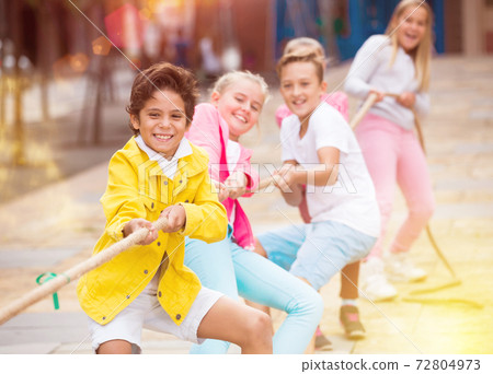 Cheerful children are competing and tug of war Cheerful children are competing and tug of war 72804973