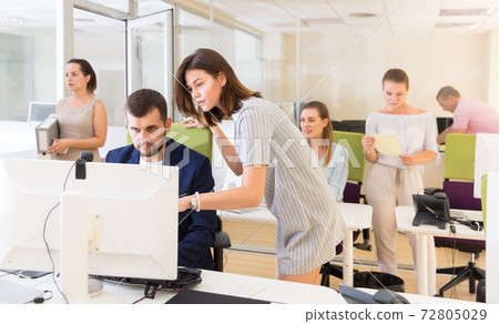 Ordinary girl helping male colleague in work Ordinary girl helping male colleague in work 72805029