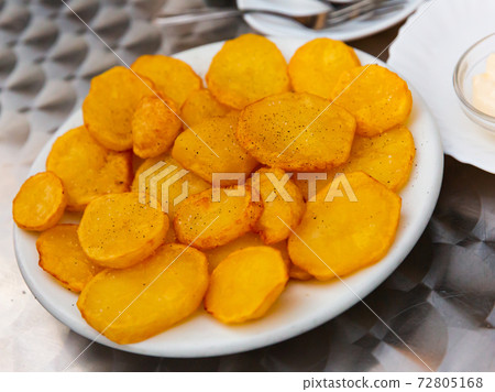 Tasty cooked baked in oven spicy potatoes served at plate 72805168