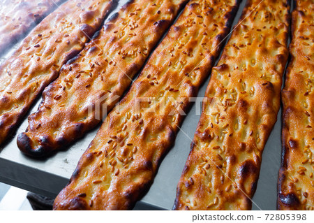 Closeup of freshly baked cocas with sesame seeds in bakery Closeup of freshly baked cocas with sesame seeds in bakery 72805398