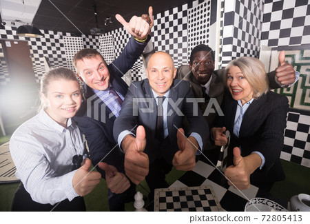 Colleagues having fun in escape room 72805413
