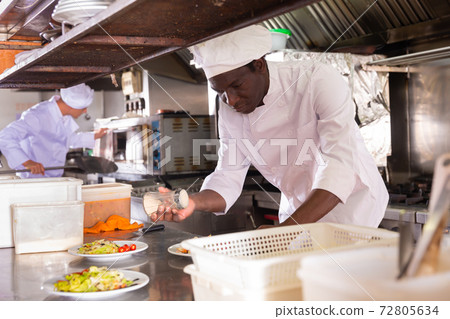 portrait of happy male cook cooking dishes in restaurante 72805634
