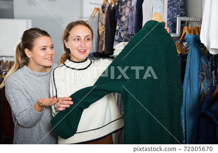 Women choosing new overcoat Women choosing new overcoat 72805670