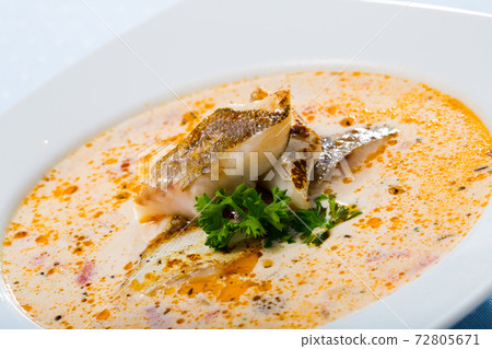 Tasty creamy soup with white fish cod and greens at white plate Tasty creamy soup with white fish cod and greens at white plate 72805671