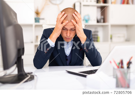 Tired businessman working with documents in office 72805706