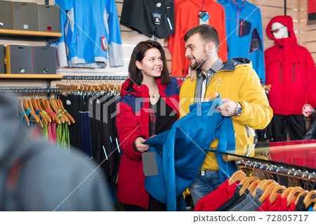 Couple choosing jacket in store Couple choosing jacket in store 72805717