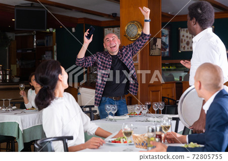 Excited happy man getting good news in restaurant 72805755