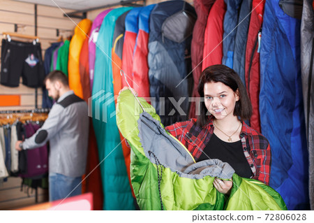 Young girl choosing new sleeping bag in store 72806028