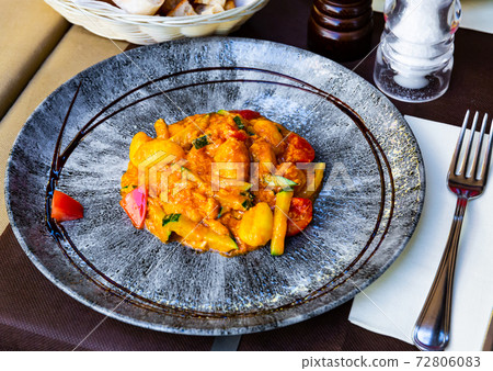 Tasty dumplings from salmon and stewed zucchini and tomatoes 72806083