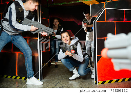 Group of young people playing laser tag game with laser guns Group of young people playing laser tag game with laser guns 72806112