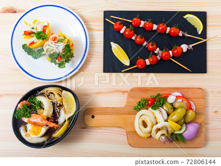 Deliciously different dishes with calamari and sepia served at desk 72806144