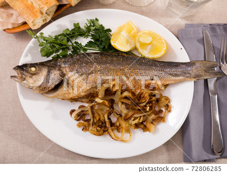 Baked sea bass with fried onion 72806285