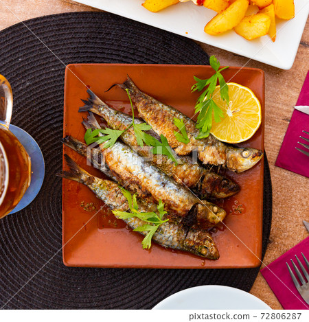 Fried sardines served with slice of lemon 72806287