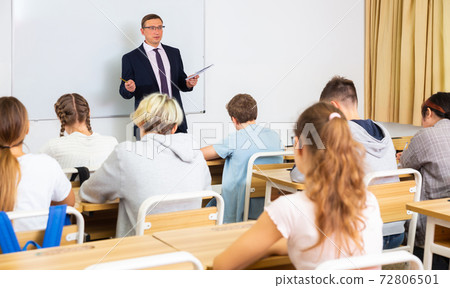 Male teacher conducting lesson for teenage schoolchildren Male teacher conducting lesson for teenage schoolchildren 72806501