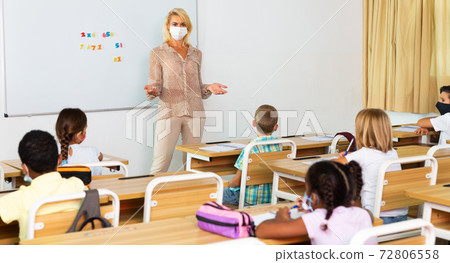 Female teacher in mask lecturing to children Female teacher in mask lecturing to children 72806558