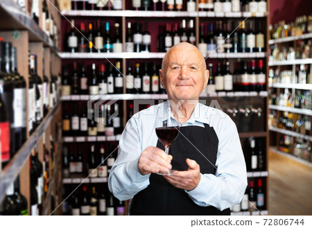 winemaker inviting to wine house, offering glass of wine for tasting 72806744