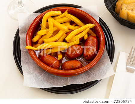 Traditional Spanish roasted chorizo sausages stewed in apple cider Traditional Spanish roasted chorizo sausages stewed in apple cider 72806784