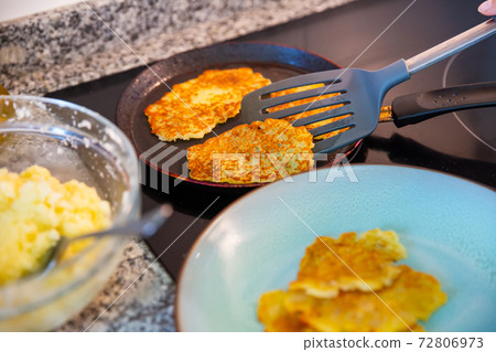 Frying potatoes pancakes at plate and in frying pan Frying potatoes pancakes at plate and in frying pan 72806973