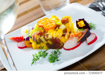 Tasty tuna tartare with mango and avocado, served with fig and flower 72806977