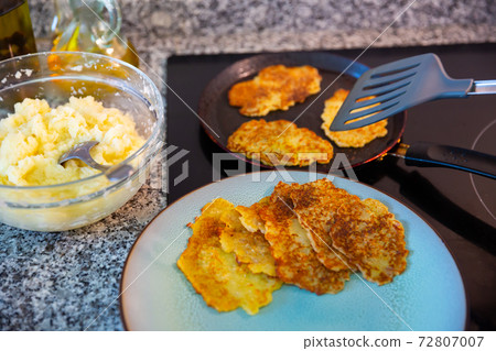 Frying potatoes pancakes at plate and in frying pan Frying potatoes pancakes at plate and in frying pan 72807007