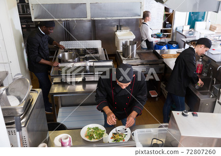 Staff of restaurant with chef working Staff of restaurant with chef working 72807260