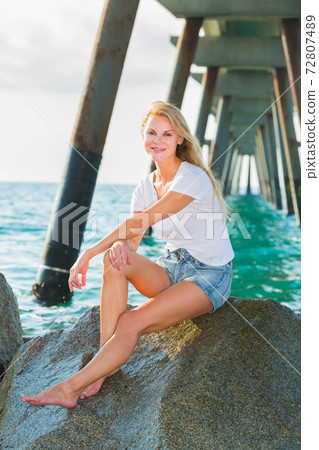 Cheerful female is posing on the rocks in her free time 72807489