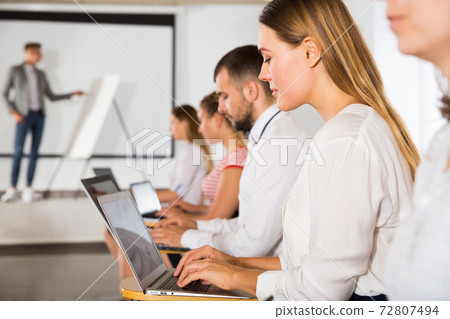 Side view of students with laptops Side view of students with laptops 72807494