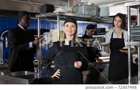 Confident woman chef in restaurant kitchen Confident woman chef in restaurant kitchen 72807498