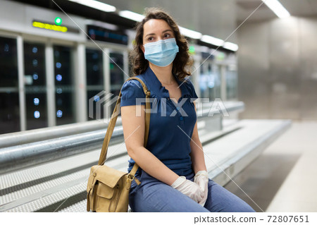 Woman in medical mask waiting for subway train Woman in medical mask waiting for subway train 72807651