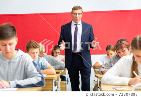 Teacher communicates freely with students in classroom at school Teacher communicates freely with students in classroom at school 72807895