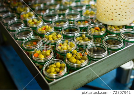 Olives and other ingredients in glass jars for canning 72807941