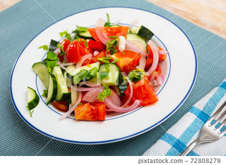 Salad from fresh tomatoes, cucumbers, red onion, parsley 72808279