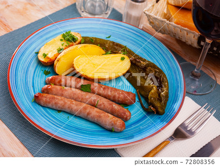 Grilled sausages with potato, pepper and herbs 72808356