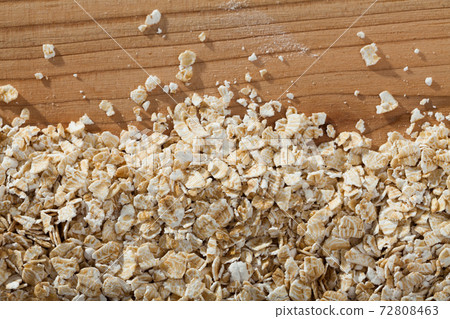 Oatmeal flakes on wooden surface 72808463