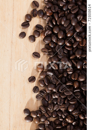 Dark coffee beans on natural wooden background, no people 72808614